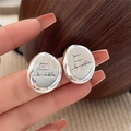 Silver oval stud earrings engraved with You are lovable text held in hand for scale - EH0622/Engraved 'You are lovable' Oval Stud
