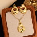 Detailed view of a gold jewelry set with swirl pendants in a wooden jewelry box - Gold Vortex Circular Jewelry Set