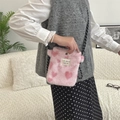 Pink heart plush crossbody bag with fluffy texture and woven strap shown on a model - Small Heart Light Pink