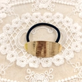 Minimalist elastic hair tie with textured golden oval metal charm on black band - Gold Ellipse Brushed