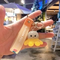 Cute gray and yellow octopus keychain with orange silicone strap and gold metal clasp - Glowing Octopus-Grey Yellow