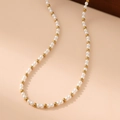 Vista detallada de la alternancia de perlas blancas y cuentas doradas de acero en el collar - 4mm / Dorado