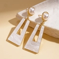 Dettaglio degli orecchini di perle con bordo dorato su base di pietra e ombre lievi - Perno in argento-Bianco / Bianco