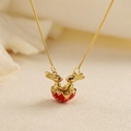 Detail shot of golden rabbit pendant with red gems on a delicate necklace chain - Red