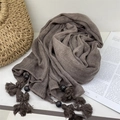 Detailed view of taupe voile scarf featuring handmade tassels and decorative beads on white - Dark Taupe