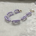 Close-up of lavender and frosted acrylic chain links with gold metal clasps on plush background - Frosted Purple