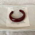 Macro detail of wine red wide resin open bangle on a minimalist textile and ceramic plate - Bangle / Burgundy