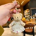 Cute teddy bear plush keychain wearing a floral dress with a golden bell and clasp - Bear (Girl)