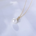 Close-up of a gold pearl necklace with zircon inlay on a soft white silk fabric - 925 Silver / Gold
