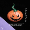 Vista macro delle dimensioni di un mini ciondolo a zucca di Halloween in resina con viso - Zucca Sorridente con Vite Verde - Arancione Scuro