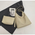 Dettaglio del set borsa a secchiello in pelle PU beige con pochette coordinata su un blazer - Set di borse a spalla / Bianco Sporco