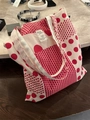 Close-up of red and white polka dot pattern on a cotton canvas tote bag with woven label - Red Polka Dot