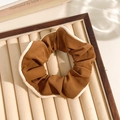 Brown floral scrunchie with white lace edges on a beige velvet tray display - Edged Brown