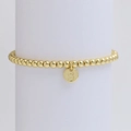 Detail shot of golden beaded bracelet with polished round letter S pendant on a display - Letter S (DB240603-S)