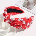 Close-up of red knotted headband with teddy bear patterns and pink faux pearls - Red Bear