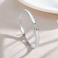 Detailed close-up of silver stainless steel bangle featuring X-shaped cubic zirconia inlay - Letter X Charm Bangle (Silver)