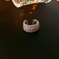 Vista detallada de un anillo abierto de plata con filas de circonitas brillantes - Anillo abierto de flor hueca / Plateado