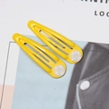 Close-up of bright yellow candy-colored drop clips with white checkered button details - Yellow