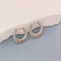 Detailed view of silver oval hoop earrings with retro etched textures on white stone - Silver Retro Etched Crescent