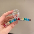 Haarklammer mit bunten Bärenfiguren auf transparentem Rahmen in der Hand gehalten - Transparente Bunte Bären-Haarklammer