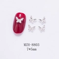 Macro shot of a 7x5mm silver metal butterfly nail charm with tiny rhinestones on red tip - Silver Butterfly With Rhinestone (8803) / 7*5mm