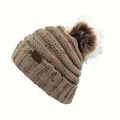 Détail d'un bonnet en tricot beige à pois colorés avec un grand pompon en fausse fourrure - Chameau