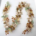 S-förmiger Herbstkranz mit Ahornblättern, weißen Kürbissen und Beeren als Wanddekoration - Rattan-Stil