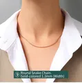 Dettaglio di una collana a catena serpente dorata da 1,3mm su modella con abito elegante - Catena a Serpente Rotonda Dorata (P873) / 40+5cm Lunghezza 1.3mm Larghezza / Oro