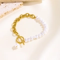 Baroque pearl and gold chain bracelet with OT toggle clasp on a textured background - OT Buckle Pearl Style
