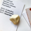 Macro view of matte gold irregular liquid-style folding socket on minimalist book - Gold