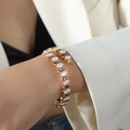 Golden spiral bangle featuring purple and clear marquise-cut zircons worn by model - Purple Zircon Gold Color