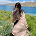 Sciarpa pied-de-poule rosa e beige in finto cashmere indossata da una modella all'aperto - 190x65cm / Cachi