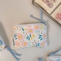 Detailed view of mini cotton pouch with floral print, zipper closure and simple wish label - White Pink Circles