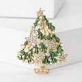 Detailed view of golden Christmas tree brooch with green enamel and sparkling rhinestones - Green