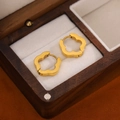 Elegant gold flower stud earrings in polished stainless steel on a wooden jewelry box - Gold