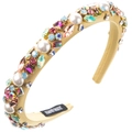Macro shot of colorful rhinestones and faux pearls on a gold satin headband - Yellow