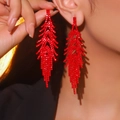 Elegant long red tassel drop earrings with sparkling rhinestones worn by a model - Glamorous Flowy Red Rhinestone Tassel
