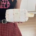 Close-up of quilted floral cosmetic bag with strap being held by a model in soft light - Red Flower Wristlet Bag (Small Mini)