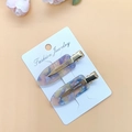 Detailed view of colorful acetate hair clips on display card with soft floral background - Acetate Pink Blue 1 Pair