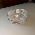 Macro-opname van de zilveren gelaagde crisscross armband met glanzende steentjes - 3# 6-laags zilveren gekruiste armband