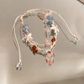 Detalle de pulsera tejida bohemia con piedras naturales de colores y estrellas de mar - Multicolor