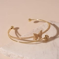 Detail of gold double-layer bangle with zircon butterfly and clover on a stone base - Gold Butterfly Double-Layer Open Bangle