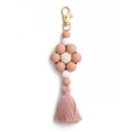 Close-up of pink and white silicone bead flower keychain with tassel and gold metal clasp - Pink