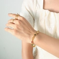 Set bracciale dorato con zirconi colorati e anelli testurizzati su una modella - Bracciale Solo (Senza Collana) / 15+5cm