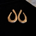 Close-up of golden irregular curved C-shaped earrings on a black velvet background - 27# Silver Needle-Gold-Twisted Teardrop-Curved Mirror