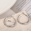 Minimalist silver hoop earrings with 30mm diameter shown on a textured stone base - Silver Needle Silver Small