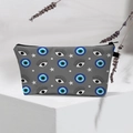 Detail of waterproof travel pouch featuring blue evil eye pattern and black zipper - 17-Grey Polka Dot Eye