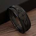 Dettaglio di un bracciale multistrato in pelle nera con trecce e ciondolo bussola in metallo - Nero + Nero Opaco