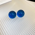 Detalle de pendientes de cuentas azul real con perlas de resina sobre bandeja blanca - Pendientes de Botón Redondos de Resina Azul / Azul