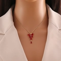 Golden butterfly tassel necklace with red and clear crystals on a female model - Red